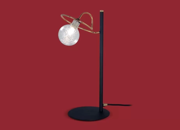 La lámpara de mesa Luciana II es un velador de metal de estilo moderno, se encuentra disponible en color cromo o en negro con bronce