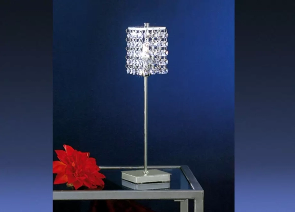 La lámpara de mesa Pyton es un velador fabricado en metal, de una luz y con decoración de cristal. El mismo está disponible en color cromo.