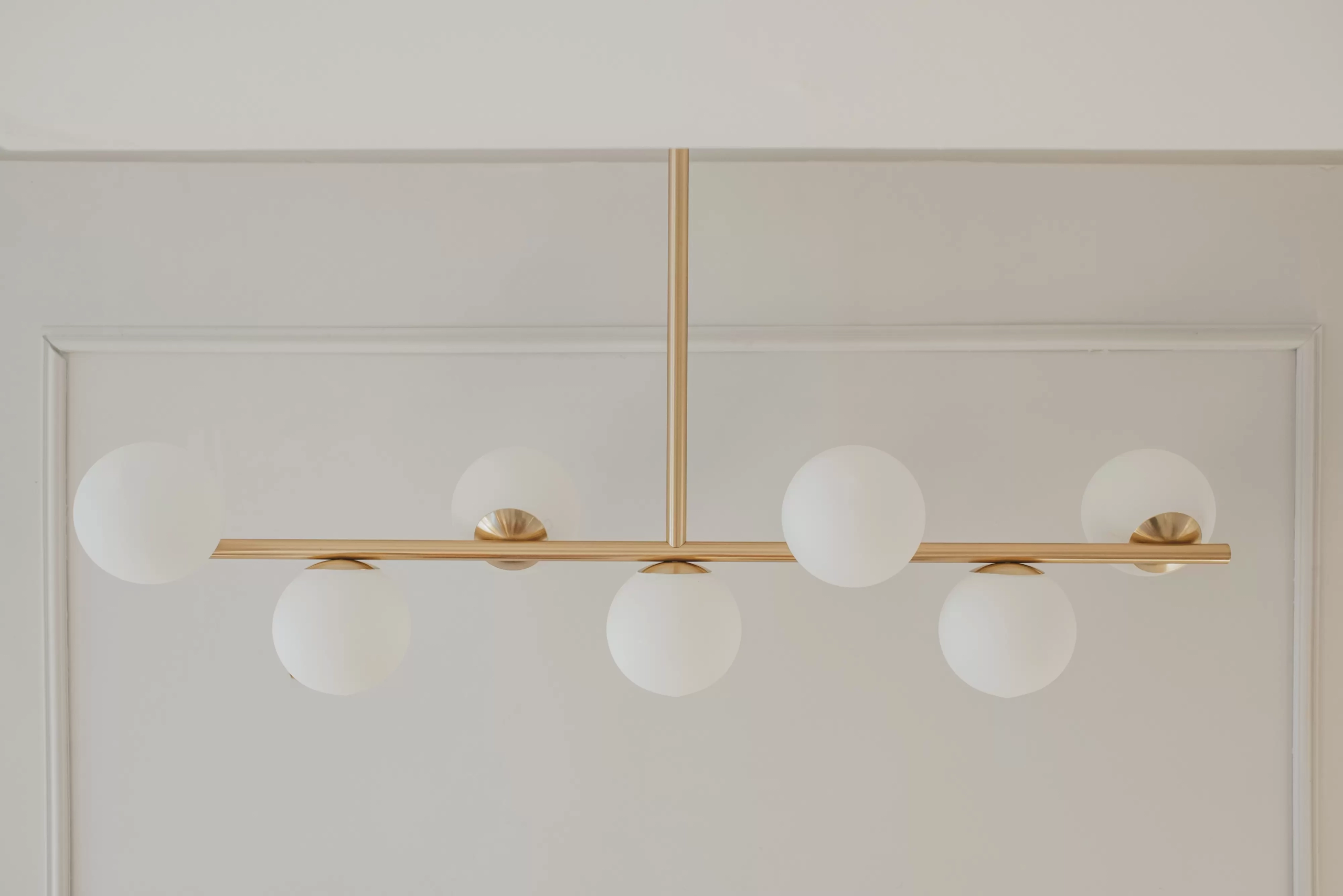Colgante T7. Luminaria moderna fabricada íntegramente en metal de 7 luces, disponible en cinco colores: negro, blanco, cobre, bronce o níquel.
